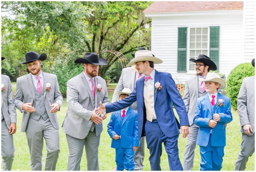 Groom shakes hands with groomsmen in cowboy hats | Coosada Alabama Wedding Photographer Amanda Horne