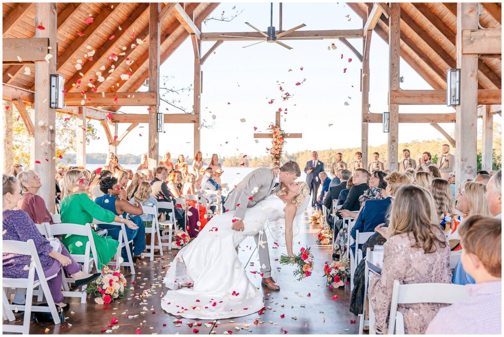 Bride and groom kiss in aisle | Lake Martin Wedding Photographer Amanda Horne