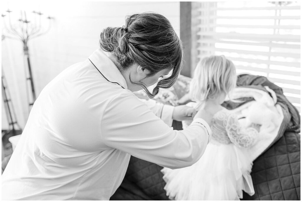 Bride dressing her daugter in flower girl dress | Alabama Wedding Photographer Amanda Horne