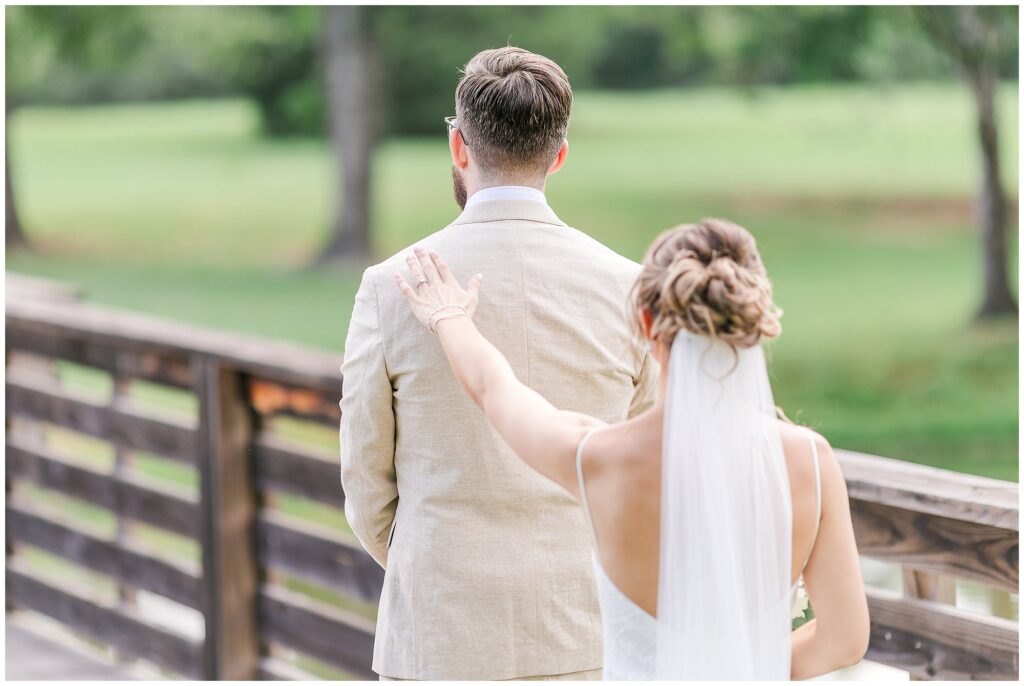 Abigail and Christopher first look by the bridge at The Farm at Lullwater