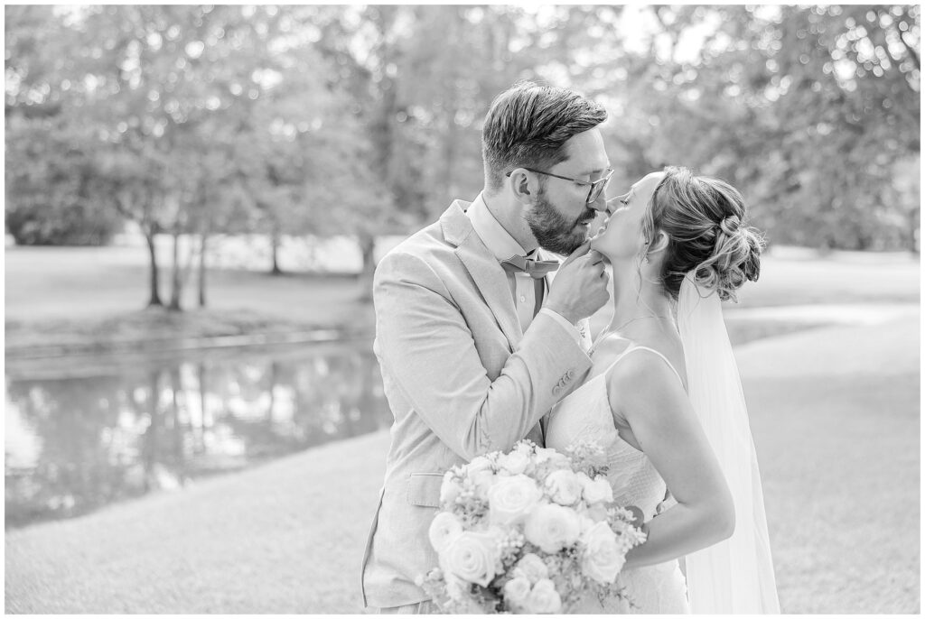 Abigail and Christopher share a romantic kiss on their wedding day at the Farm at Lullwater 