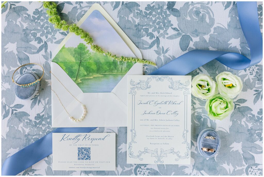 Flatlay of wedding invitation suite and blue floral details.