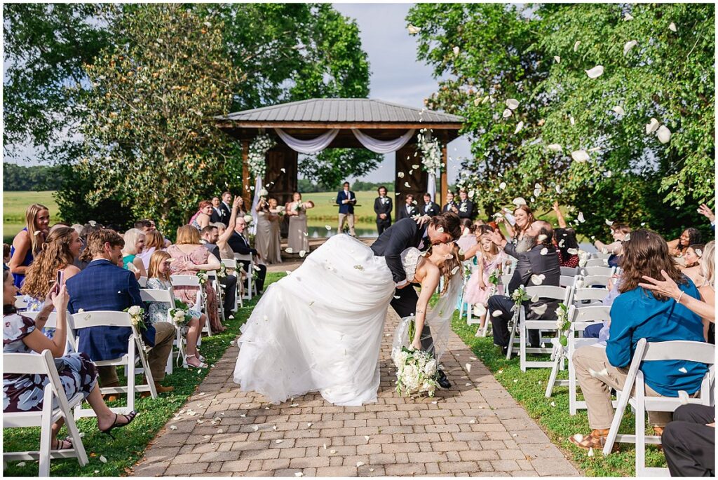 Bride and groom kissing during their petal exit

